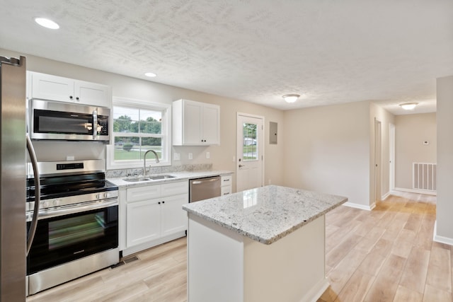 kitchen featuring white cabinets, light hardwood / wood-style floors, stainless steel appliances, and sink