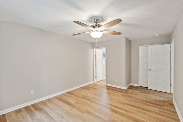 unfurnished bedroom with light hardwood / wood-style floors, ceiling fan, and a textured ceiling