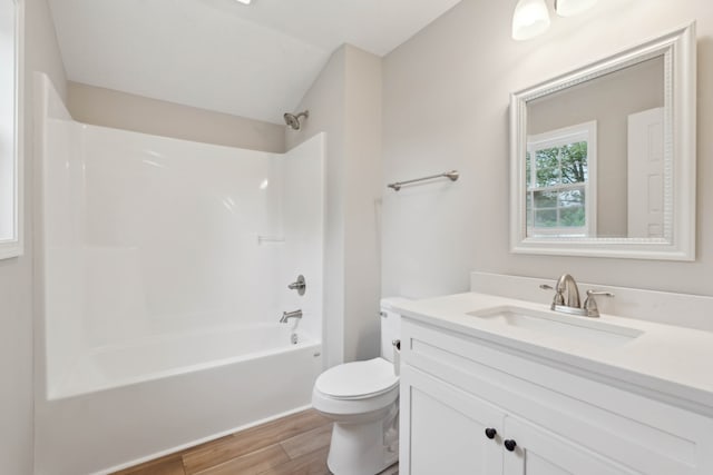 full bathroom featuring vanity, hardwood / wood-style flooring, toilet, and washtub / shower combination