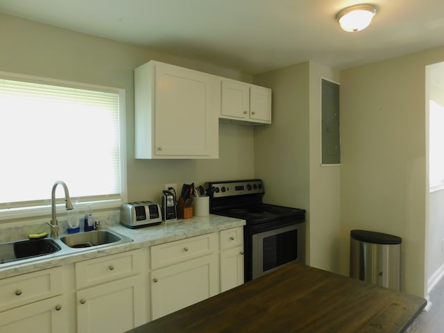 kitchen featuring white cabinetry, electric stove, light stone counters, electric panel, and sink