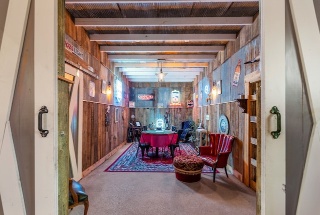 sitting room with beam ceiling and wood walls