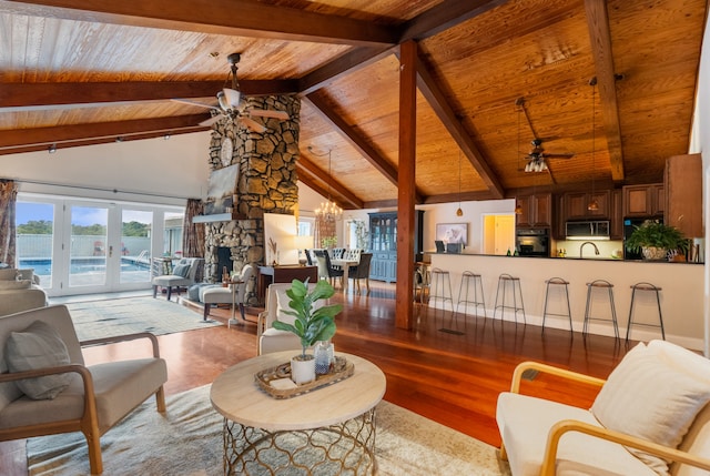 living room with beamed ceiling, a fireplace, light hardwood / wood-style flooring, ceiling fan, and wooden ceiling