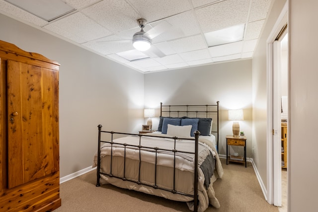 bedroom featuring carpet, ceiling fan, and a paneled ceiling