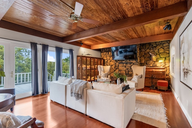 living room featuring wood ceiling, a stone fireplace, beam ceiling, ceiling fan, and hardwood / wood-style floors