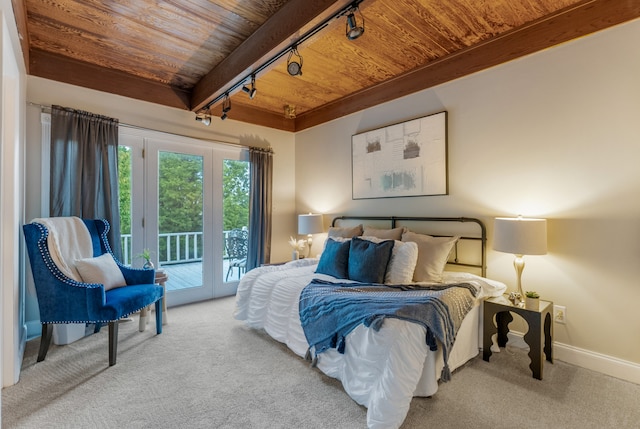 bedroom featuring track lighting, access to exterior, beam ceiling, light carpet, and wooden ceiling