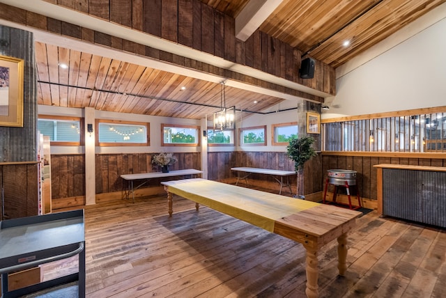 unfurnished dining area with wooden ceiling, wood walls, high vaulted ceiling, and hardwood / wood-style flooring