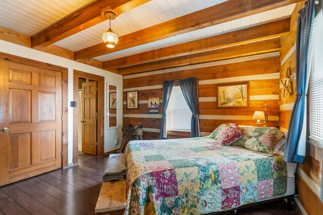 bedroom with multiple windows, beam ceiling, wooden walls, and dark wood-type flooring