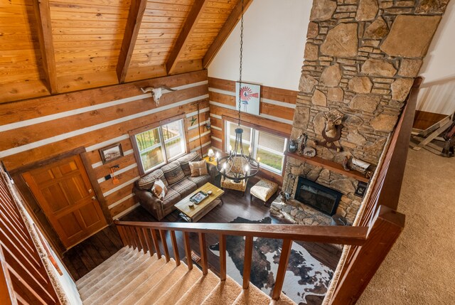 carpeted living room with a fireplace, beam ceiling, a chandelier, and plenty of natural light