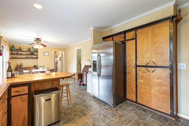 kitchen with ornamental molding, wood counters, ceiling fan, and stainless steel fridge with ice dispenser