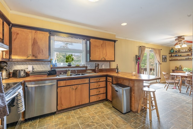 kitchen with kitchen peninsula, backsplash, sink, appliances with stainless steel finishes, and ceiling fan