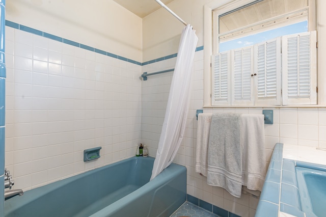 bathroom featuring shower / bath combo with shower curtain and tile walls