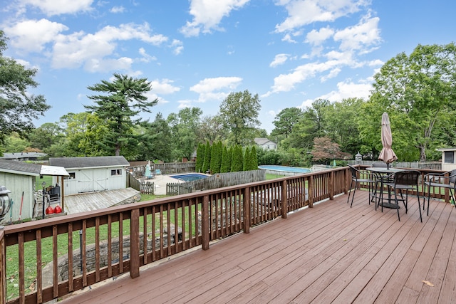 deck featuring a storage unit and a pool