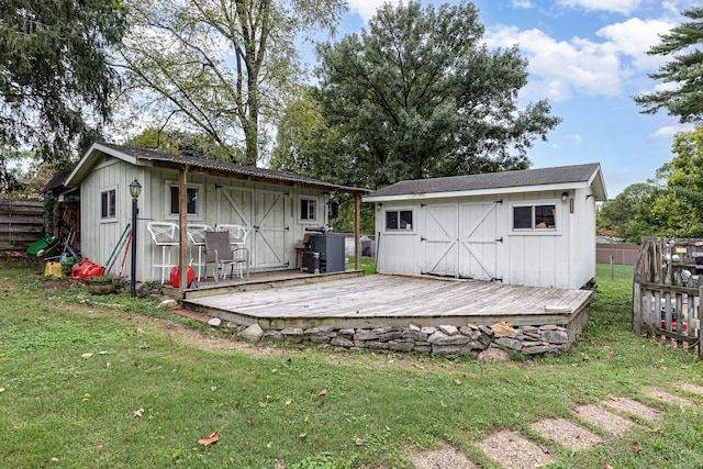 back of property featuring a yard, a storage unit, and a wooden deck