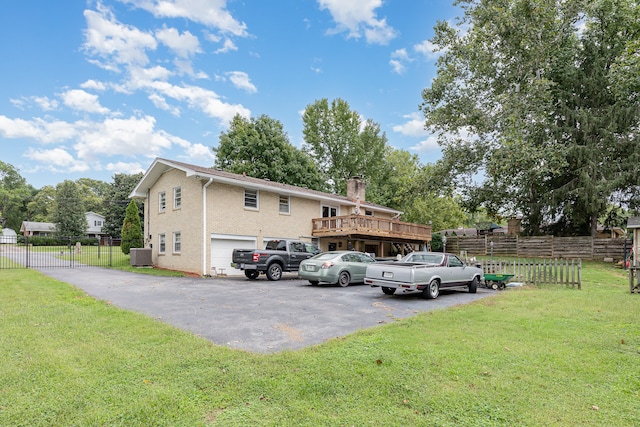 exterior space featuring a front yard, a deck, central AC, and a garage