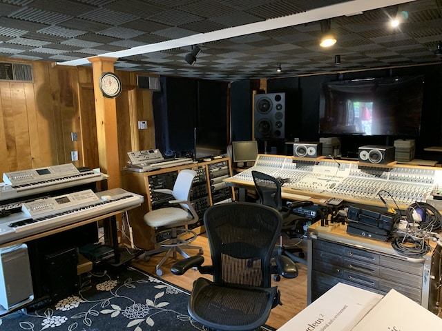 misc room with dark wood-type flooring and wooden walls