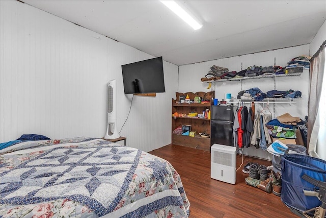 bedroom featuring wooden walls and dark wood-type flooring