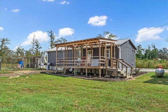 back of property with a lawn and a wooden deck