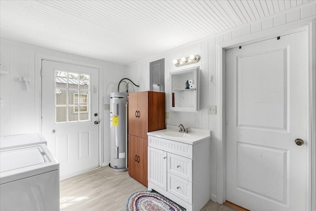 bathroom with vanity, wood walls, wood-type flooring, water heater, and washer and dryer