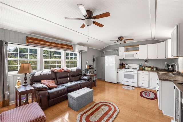 living room featuring vaulted ceiling, sink, light hardwood / wood-style flooring, and ceiling fan