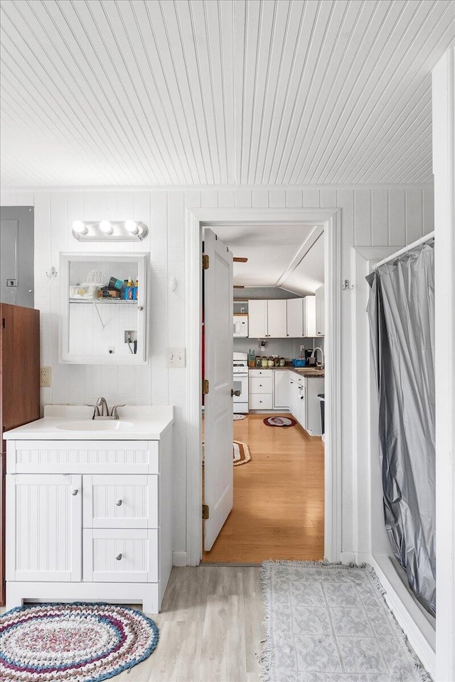 bathroom with a shower with shower curtain, wood-type flooring, and vanity