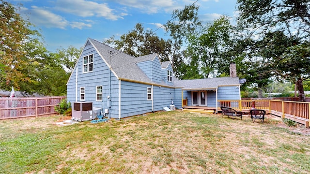 back of house featuring a lawn and a deck