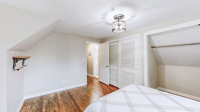 bedroom with lofted ceiling, a closet, and hardwood / wood-style floors