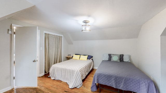 bedroom with lofted ceiling and hardwood / wood-style floors