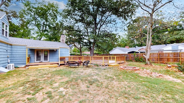 view of yard featuring a deck, french doors, and a fire pit