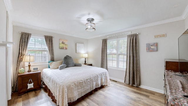 bedroom with light hardwood / wood-style floors and crown molding