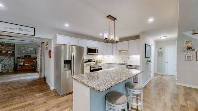 kitchen with a kitchen island, white cabinetry, sink, and stainless steel appliances