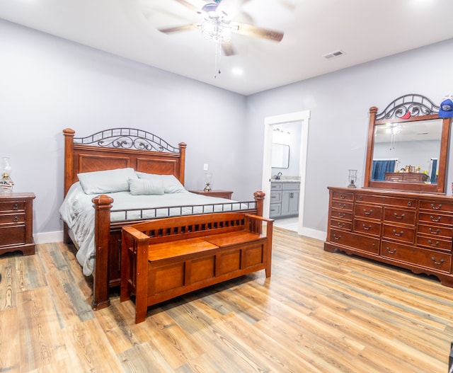 bedroom with connected bathroom, ceiling fan, and light hardwood / wood-style flooring