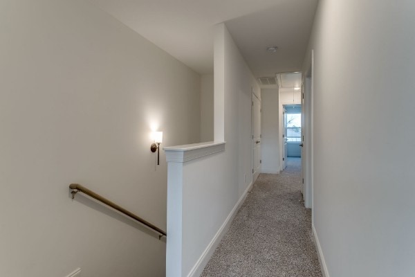 hallway featuring light colored carpet