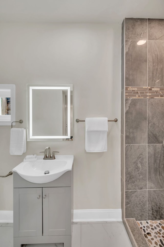 bathroom with vanity and tiled shower