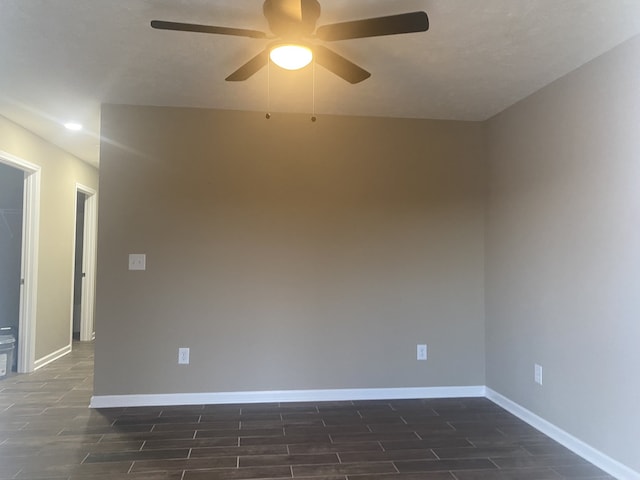 empty room with ceiling fan and dark hardwood / wood-style flooring