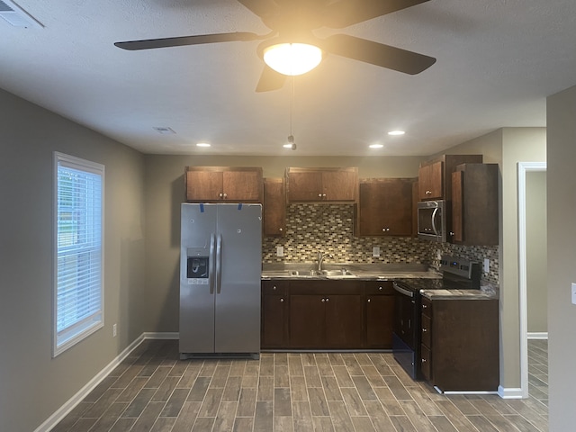 kitchen featuring hardwood / wood-style flooring, sink, stainless steel appliances, backsplash, and ceiling fan