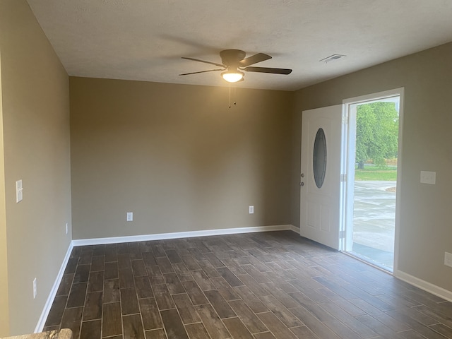 entrance foyer featuring ceiling fan, a textured ceiling, and dark hardwood / wood-style flooring