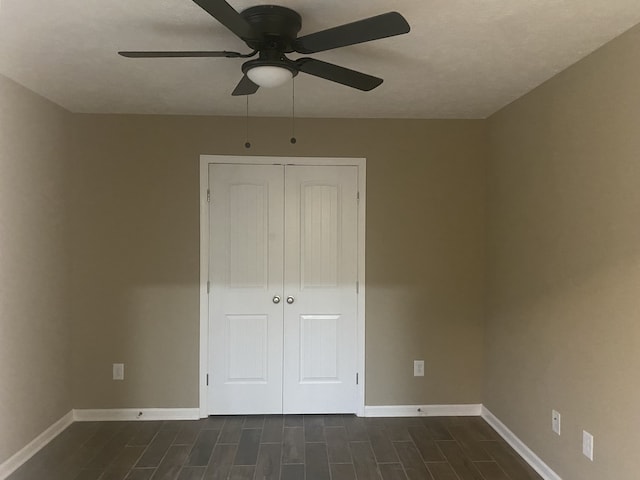 unfurnished bedroom with ceiling fan, a closet, and dark hardwood / wood-style floors