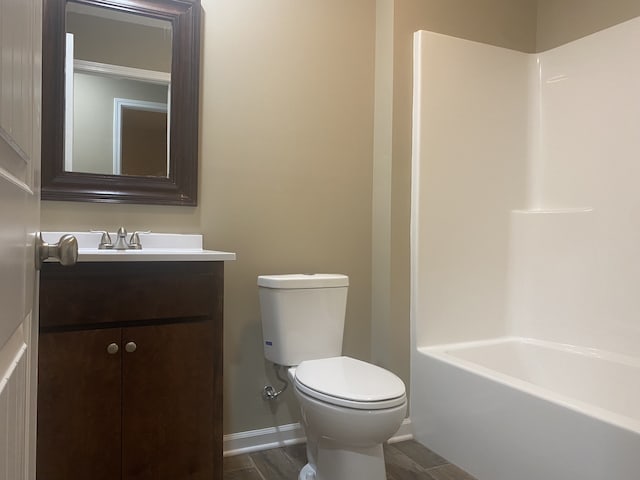 full bathroom with wood-type flooring, vanity, bathtub / shower combination, and toilet