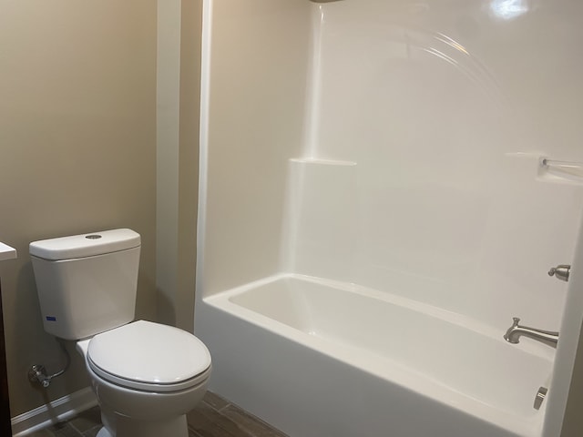 bathroom featuring shower / tub combination, hardwood / wood-style flooring, and toilet