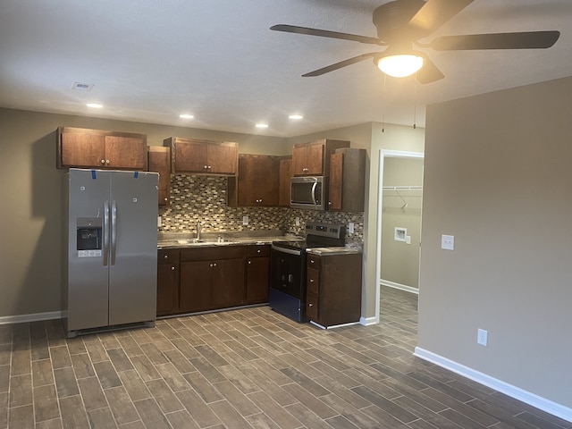 kitchen with ceiling fan, sink, hardwood / wood-style flooring, appliances with stainless steel finishes, and decorative backsplash