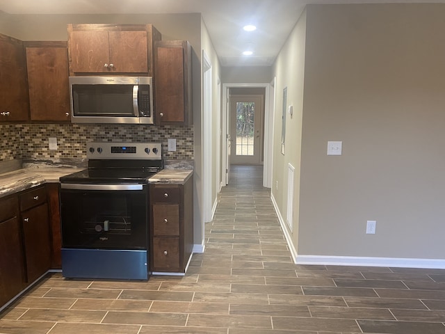 kitchen featuring dark brown cabinets, appliances with stainless steel finishes, and tasteful backsplash