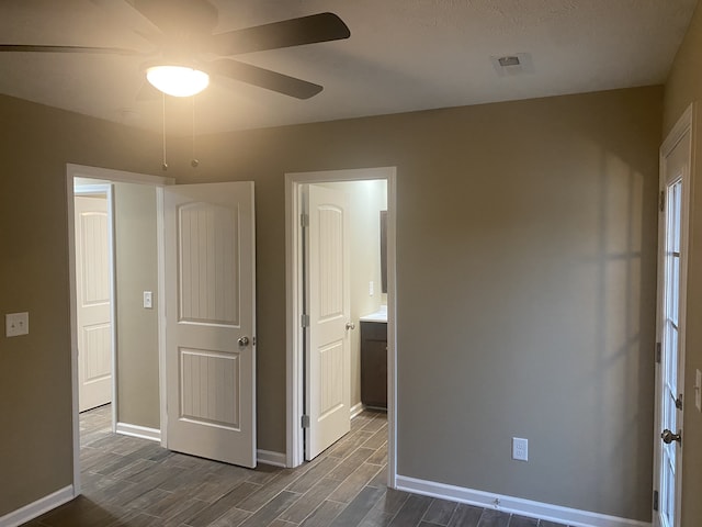 spare room featuring ceiling fan, dark wood-type flooring, and a textured ceiling