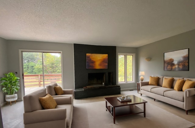 living room with a textured ceiling, light colored carpet, and a fireplace