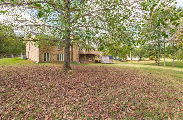 view of front of home featuring a storage unit, cooling unit, and a front yard