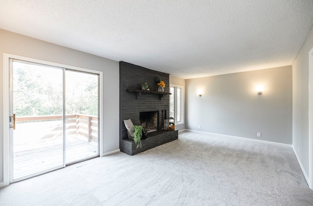 unfurnished living room with a textured ceiling, light colored carpet, and a fireplace