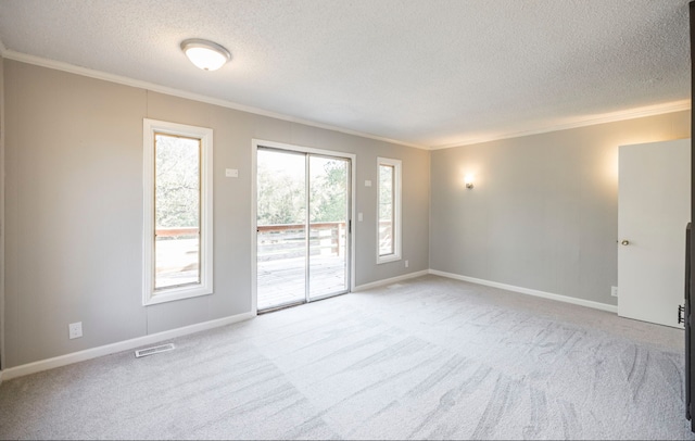 unfurnished room with a textured ceiling, light colored carpet, and crown molding