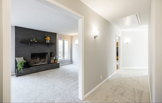 hallway featuring light carpet and a textured ceiling