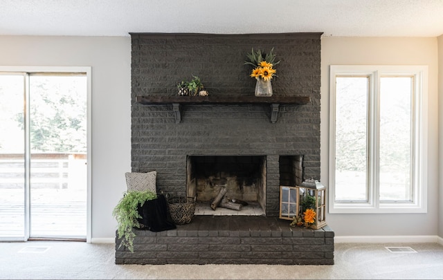 room details featuring a textured ceiling, carpet, and a fireplace