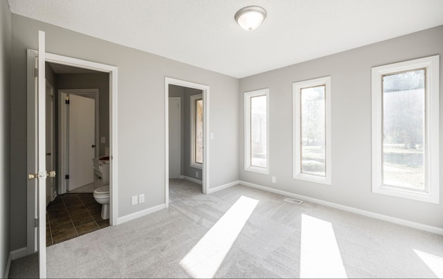 unfurnished bedroom with light carpet and ensuite bath