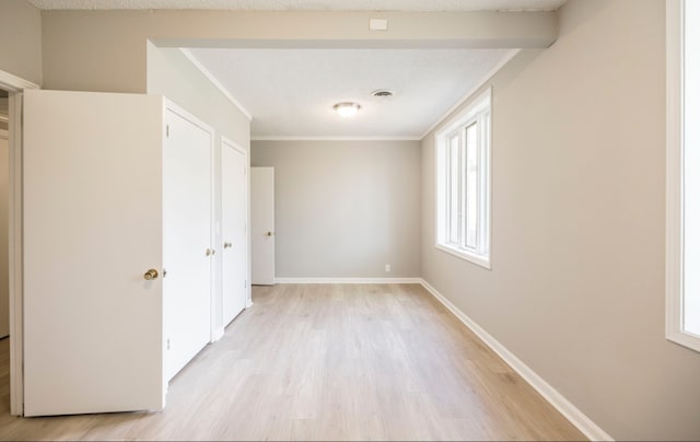 unfurnished bedroom featuring light hardwood / wood-style flooring and ornamental molding